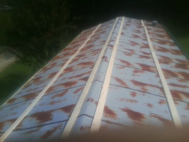 Rusted metal roof panels with new wood purlins before replacement — Storm Damage Roof Repair in Athelstane by Roofing Brothers